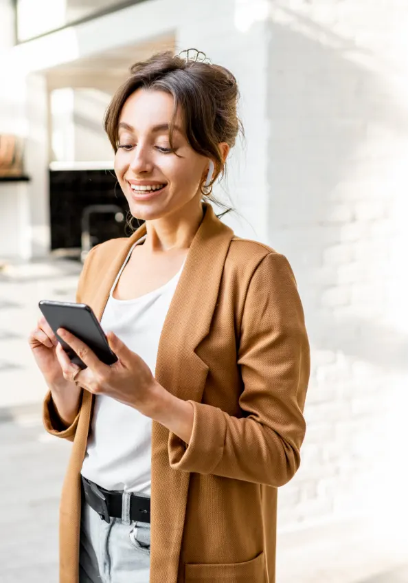 Femme souriante devant son smartphone